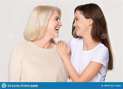 Happy Young Daughter Embracing Mature Mother Laughing Isolated On