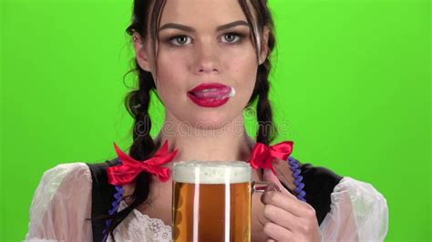 Oktoberfest Girl Flirting And Drinking Beer From A Glass Green Screen Slow Motion Stock