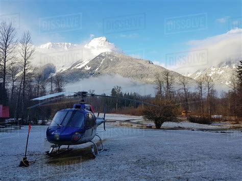 Bella Coola Heliski Canada Blue Helicopter Parked In The Large Meadow