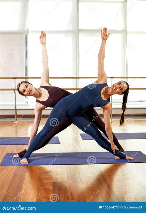 Beautiful Young Women Doing Paired Stretching Exercises The Girls In The Gym Do Fitness