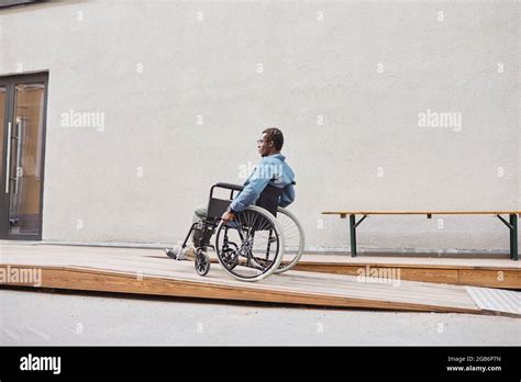 Young African American Man With Paralyzed Legs Sitting In Wheelchair