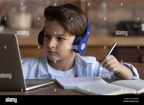 Preteen Boy In Headset Study From Home Using Laptop Computer Stock