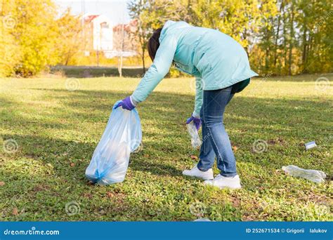A Female Volunteer Cleans Plastic Garbage In Nature Stock Photo