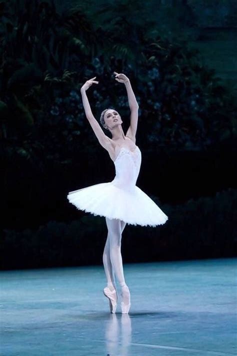 the ballerina is dressed in white and dancing