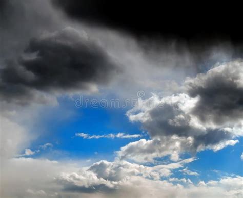 Stormy Clouds In The Blue Sky With The Dawn Of The Sun Rays Stock Photo