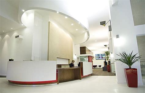 An Office Lobby With White Walls And Red Accents
