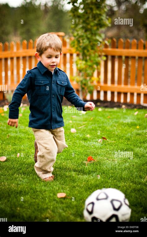 Young Boy Playing Football In Back Garden Hi Res Stock Photography And