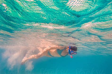 woman in bikini snorkeling underwater at all inclusive caribbean resort white sand beach by jp