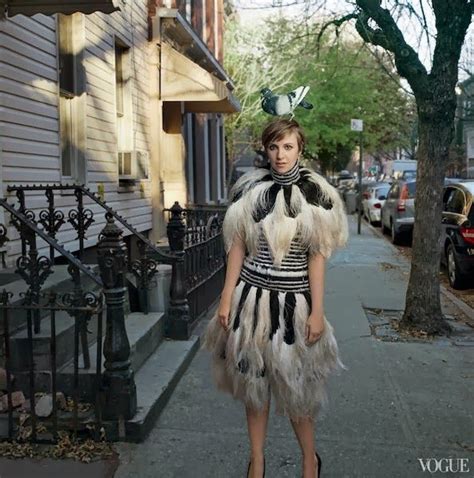 A Woman Is Standing On The Sidewalk Wearing A Dress With Feathers And Bow Tie