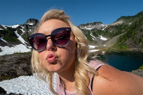 Blonde Woman Makes A Duck Face Kisses Pose At Heather Meadows In The Mt