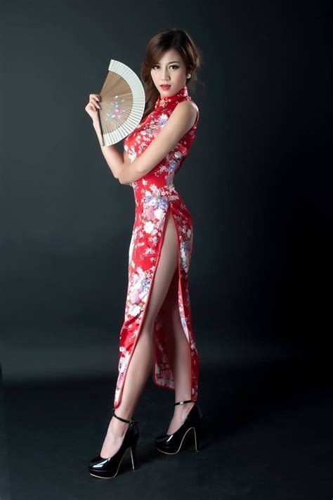A Woman In A Red And White Dress Holding A Fan While Posing For The Camera