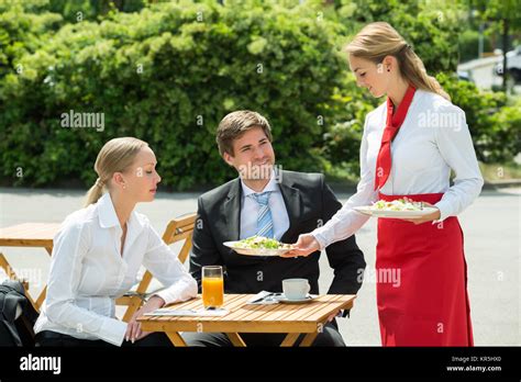 Waitress Serving Food To Businesspeople Stock Photo Alamy