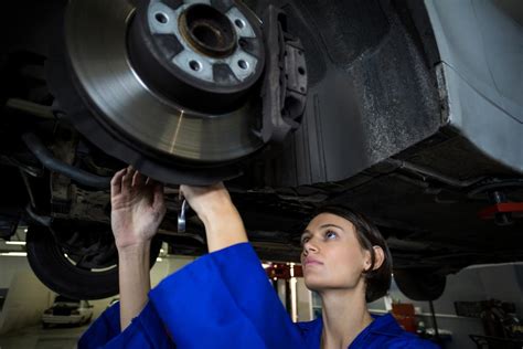 Female Mechanic Fixing A Car Wheel Disc Brake Free Photo