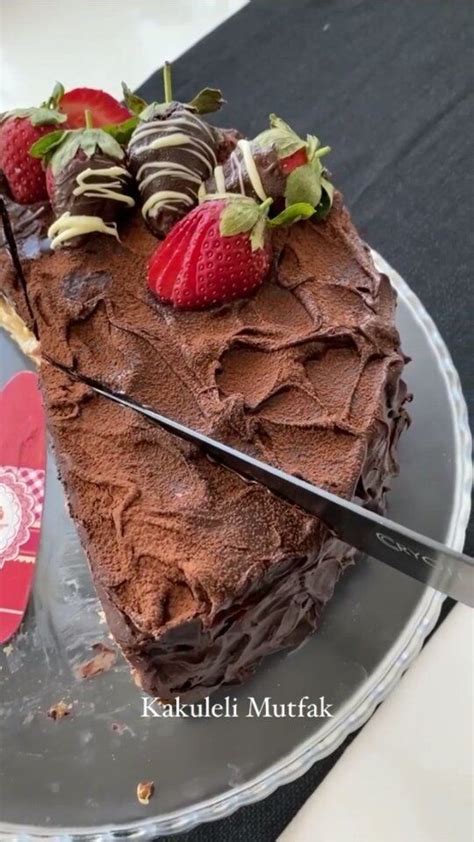 A Chocolate Cake With Strawberries On Top And A Knife Stuck In The