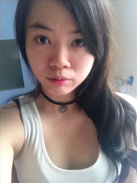 A Woman With Long Hair Wearing A White Tank Top And Black Choker Around Her Neck
