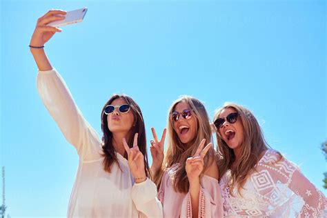 three girls taking smiling selfie by stocksy contributor guille faingold stocksy