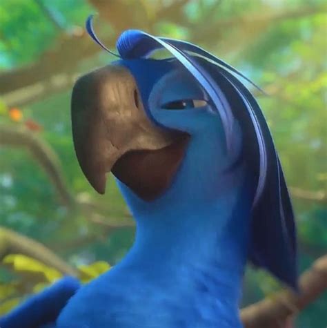The Blue Bird Is Smiling While Standing In Front Of Some Leaves And