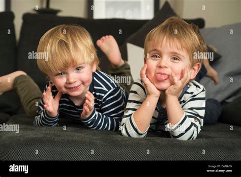 Two Little Boys Playing At Home Lying On Couch Stock Photo Alamy