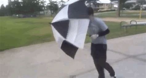 People Struggling Comically With Umbrellas In The Wind People Struggle People Giphy