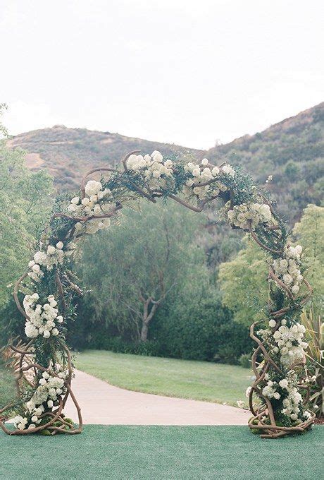 A Classic Arch Of Intertwining Branches Hydrangeas And Roses