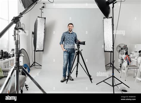 Professional Photographer Posing In The Studio And Holding A Digital
