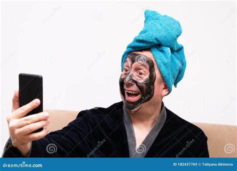 A Fun Concept Of Cosmetology A Funny Fat Man With A Black Cream Mask On His Face In A Dressing