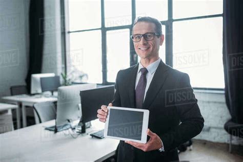 Portrait Of Smiling Businessman Showing Tablet With Blank Screen In