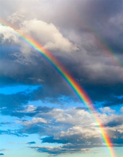 Bright Rainbow In Blue Sky With White Clouds Vertical