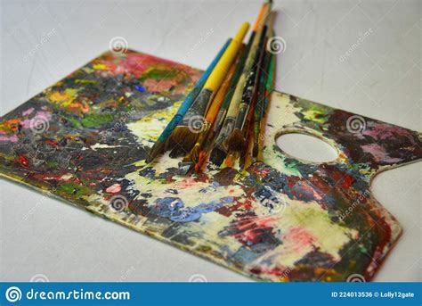Artist Brushes Laying On A Colorful And Used Painter S Pallette Stock