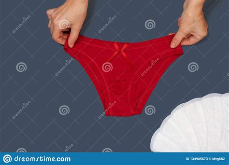 women`s hands with beautiful panties and sanitary pads on gray background stock image image of