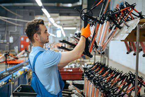 Bicycle factory, worker at bike assembly line - VTC Insurance Group