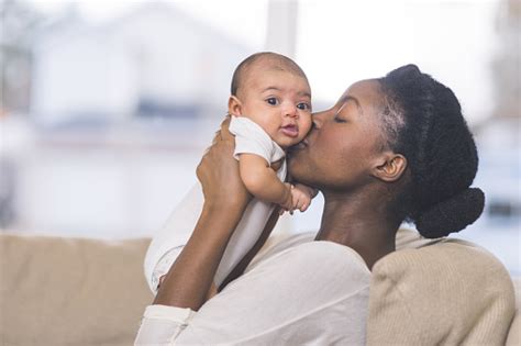 Beautiful African American Mother Holds Newborn Baby In The Living Room