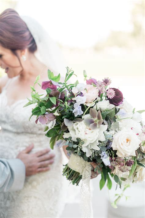 The Bride And Groom Are Holding Their Wedding Bouquet