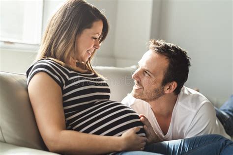 una mujer embarazada del hombre feliz del concepto del embarazo y de la gente en casa imagen de