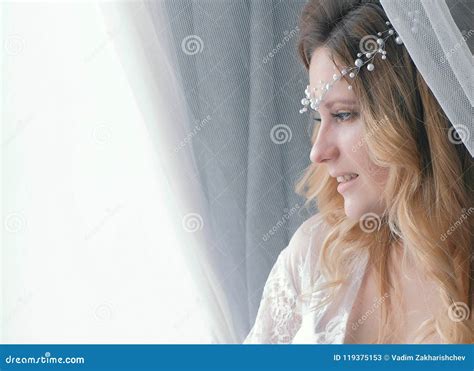 jeune fille blonde sexy mince dans la lingerie et boudoir regardant la fenêtre verticale de plan