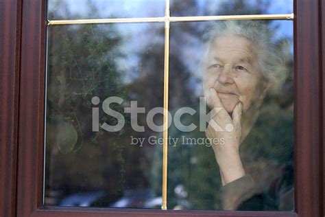 Elderly Woman Looking Through The Window Stock Photo Royalty Free