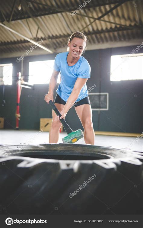 modelo fitness femenino haciendo ejercicio cross fit gimnasio con martillo fotografía de stock