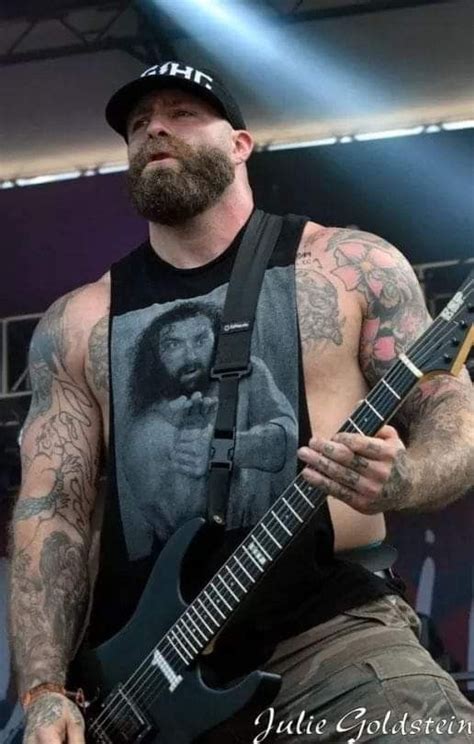 a man with tattoos playing an electric guitar