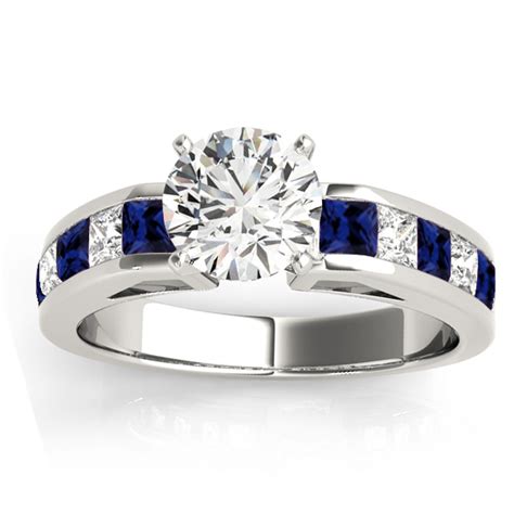 This ring showcases a vivid emerald gemstone accented with diamond baguette side stones, and framed with sparkling round diamonds in 14k white gold. Diamond & Blue Sapphire Accents Engagement Ring 14k White ...