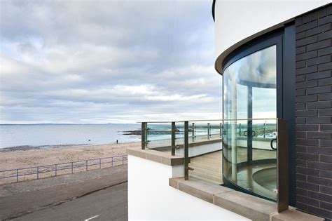 Curved windows 'thrust for the view' at Promenade House | glassonweb.com