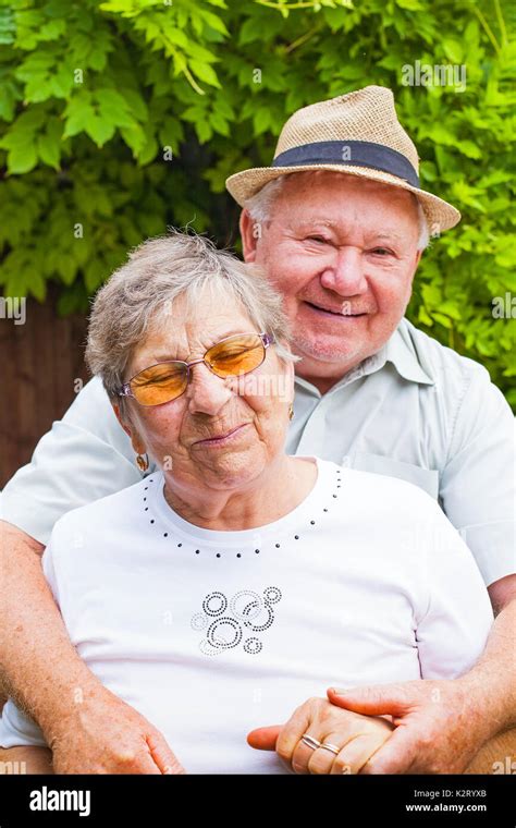 Cute Elderly Couple In Love Hugging And Smiling Outdoor In The Green