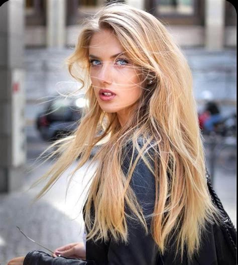 A Woman With Long Blonde Hair Walking Down The Street