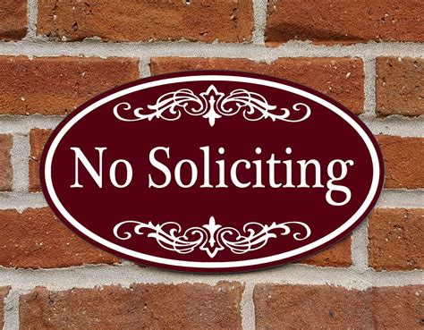 A Brick Wall With A Sign That Says No Soliciting On Its Side