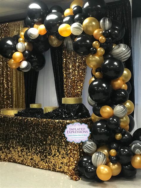 Black Gold And Silver Balloons In The Shape Of An Arch On Display At A