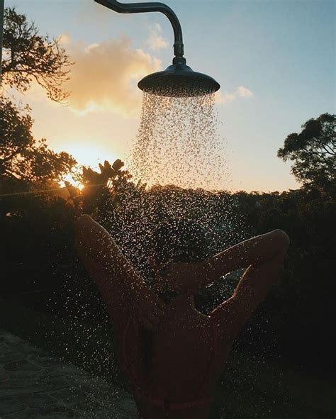 A Person In The Water Spraying From A Faucet With Their Back To The Camera