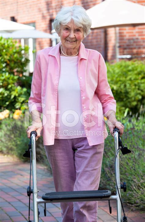 Elderly Lady Using A Walker In The Stock Photos