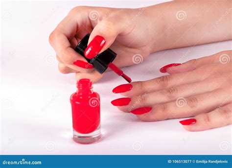 Woman Painting Her Nails On Finger In Red Color On White Background