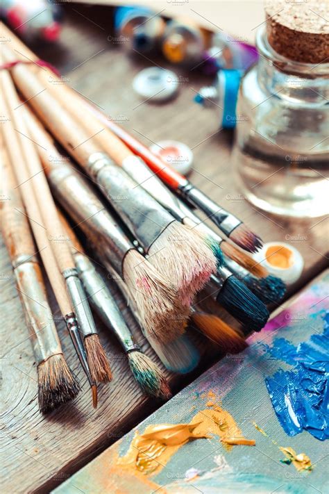 An Assortment Of Paintbrushes And Brushes On A Wooden Table