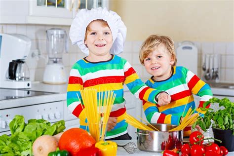Two Little Kid Boys Cooking Pasta With Vegetables Stock Image Image