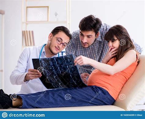 Pregnant Woman With Her Husband Visiting The Doctor In Clinic Stock Image Image Of Husband
